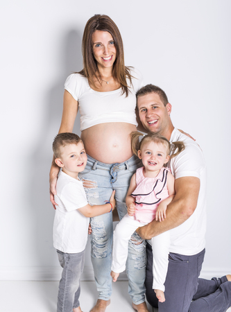 Happy family with two kids on studio gray backgroundの写真素材