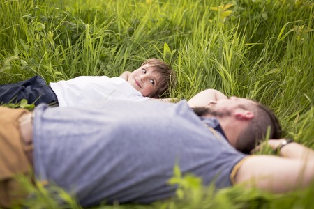 A Father and son having fun outdoors in the meadowの写真素材