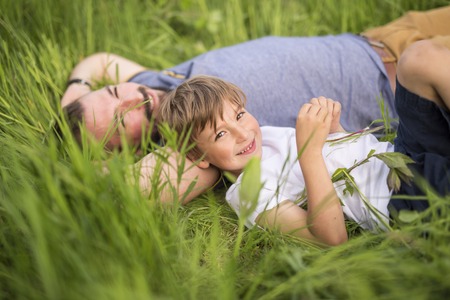 A Father and son having fun outdoors in the meadowの写真素材