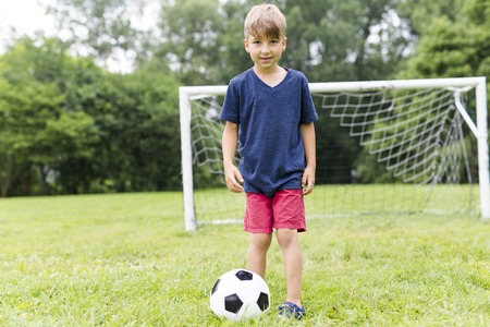 A Young Boy with football on a field having funの写真素材
