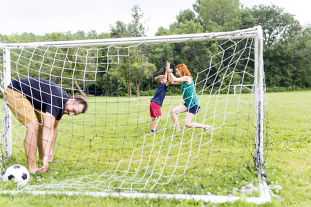 A Cheerful family playing football in a parkの写真素材