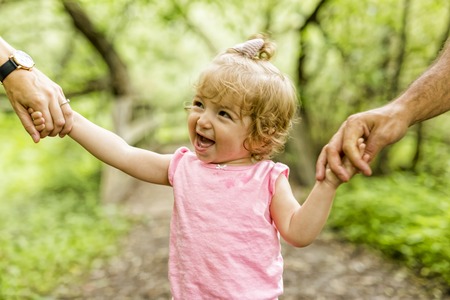 A Mother, father and daughter on the promenade. First stepsの写真素材