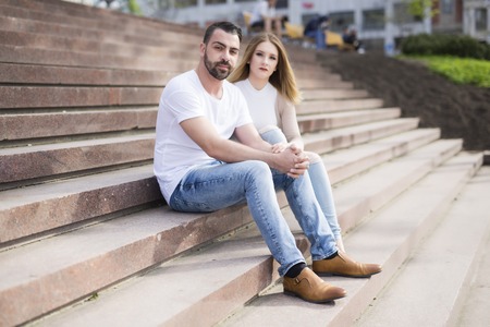 A Young couple sitting in stairs at university campusの写真素材