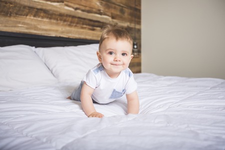 Cute Baby boy in white bedding.の写真素材