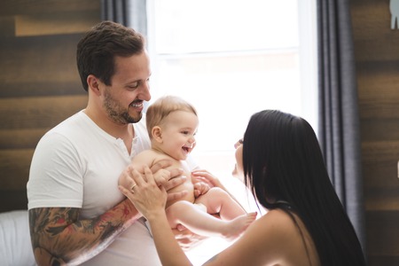 baby with mother and father in the roomの写真素材