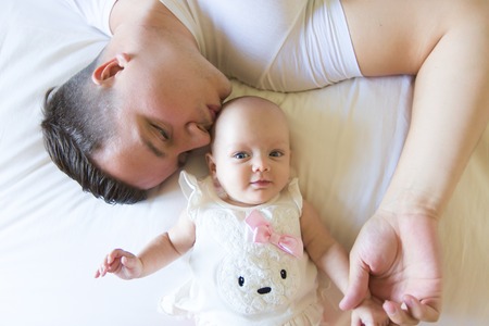 Portrait of father with her 3 month old baby in bedroomの写真素材