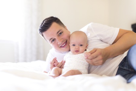 Portrait of father with her 3 month old baby in bedroomの写真素材