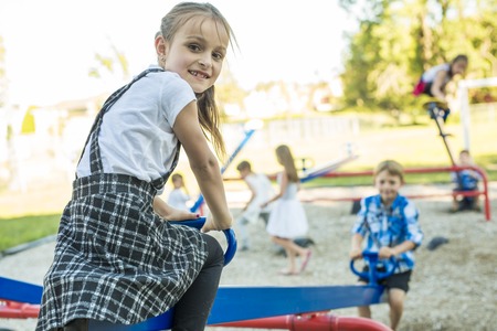 cheerful school age child play on playground schoolの写真素材