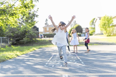 cheerful school age child play on playground schoolの写真素材