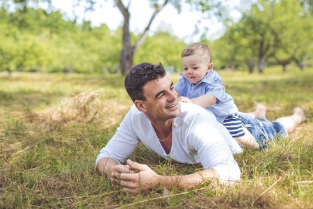 beautiful father little toddler son on the meadow.