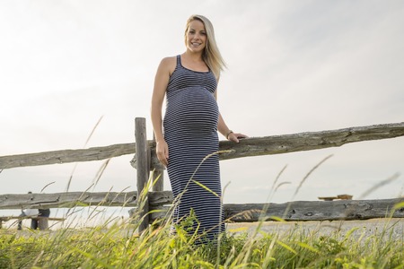 Portrait of a young beautiful blond pregnant woman on the side of the beachの写真素材
