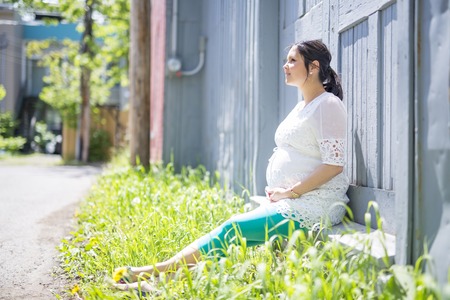 Pregnant woman posing in the neighborhoodの写真素材