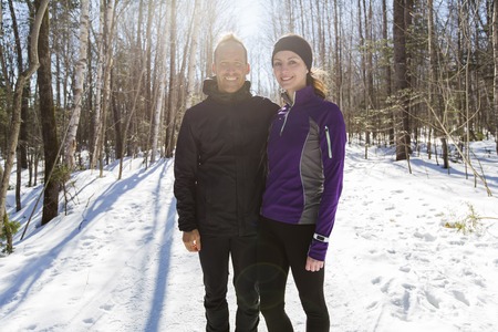 Winter running exercise couple. Runners jogging in snow.