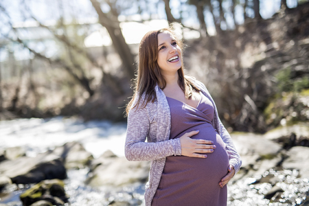 Pretty pregnant woman in sunny spring day