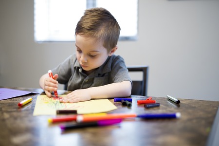 Young Boy Drawing on the kitchen tableの写真素材