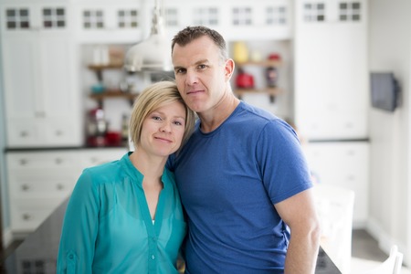Happy couple in kitchen having fun togetherの写真素材