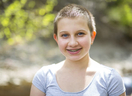 teen with shaved head outside in forestの写真素材
