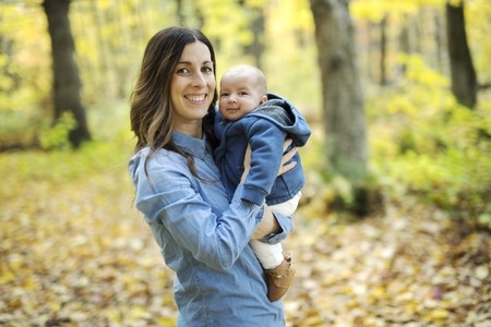 Mother with daughter baby in autumn forest
