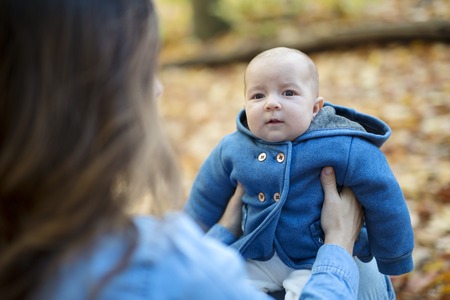 Mother with daughter baby in autumn forestの写真素材