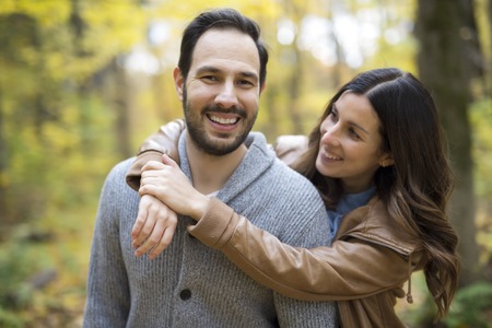 Nice couple having fun in autumn parkの写真素材