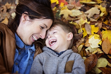 Mother with son in forest in autumnの写真素材
