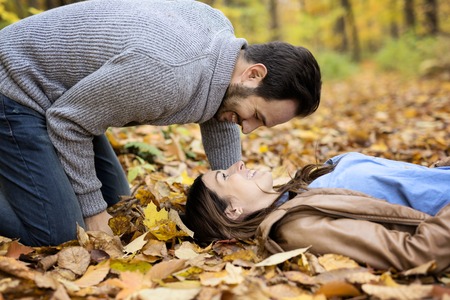 Nice couple having fun in autumn parkの写真素材
