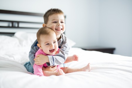 baby and his brother on bed