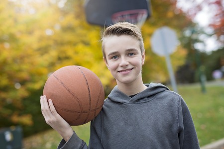 Boy alone during basketball game outsideの写真素材