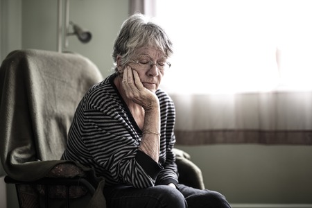 worried senior woman at home felling very bad