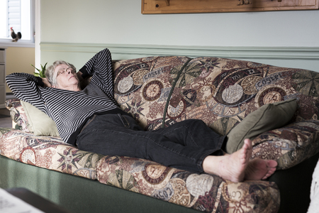 Senior woman relaxing on sofaの写真素材