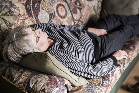 Senior woman relaxing on sofaの写真素材