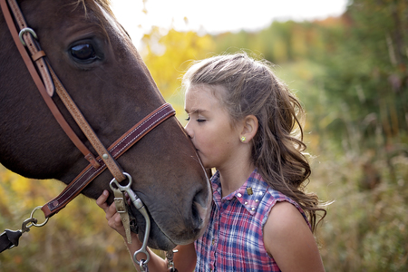 Autumn season young girl and horseの写真素材