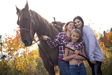 three adult woman outdoors with horse childの写真素材