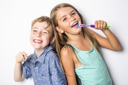 Cute little child brushing teeth, isolated on whiteの写真素材