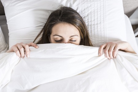 A Young sleeping woman in bedroom at home wearing in white