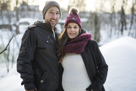 Pregnant couple have fun in winter natureの写真素材