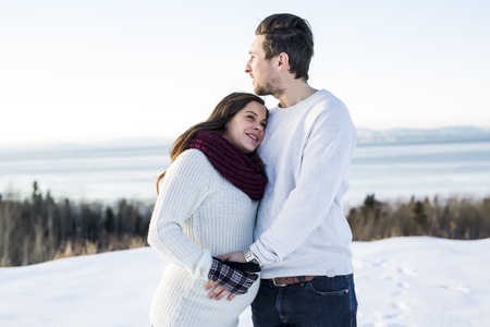 Pregnant couple have fun in winter natureの写真素材