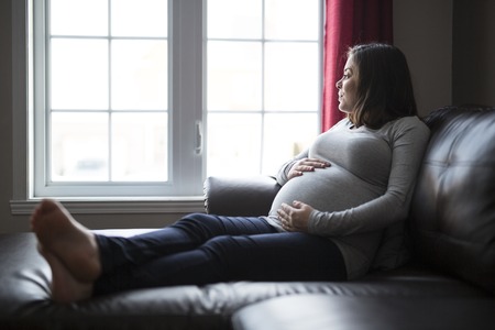 young pregnant woman close to the window