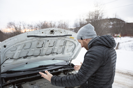 Man problem close to the broken car in winterの写真素材