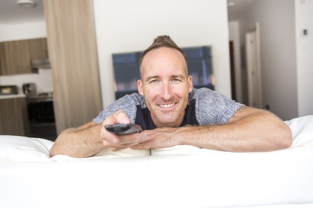 man on sofa linstening TVの写真素材