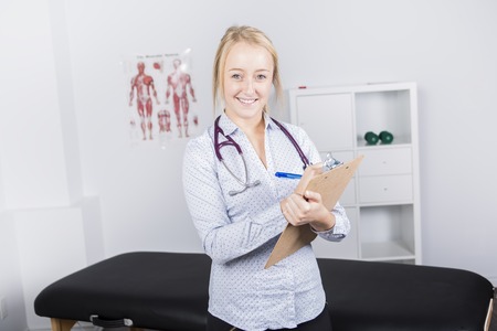 Portrait of smiling doctor looking at camera in medical officeの写真素材
