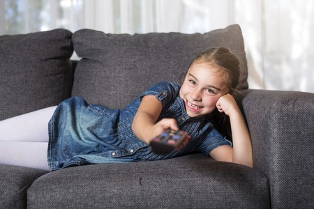 eight years old child on a sofa at homeの写真素材