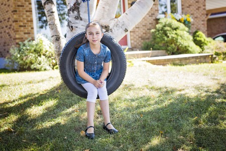 Portrait of girl on tire swingの写真素材