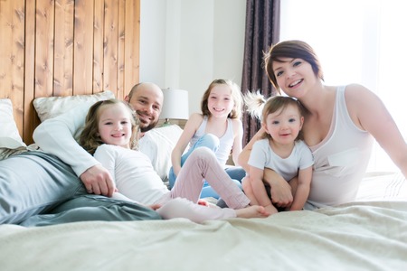 A Young happy family of five on bedroomの写真素材