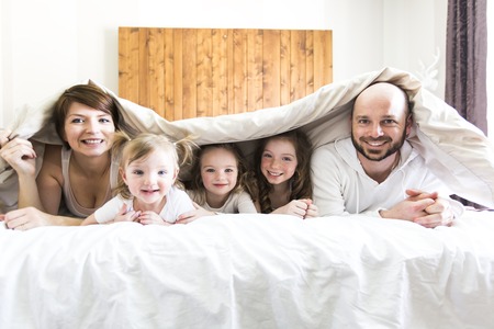 A Young happy family of five on bedroomの写真素材