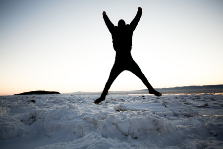 A young tourist jumping lake in background, Iceland