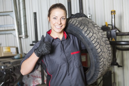 A Mechanic woman working on car in his shopの写真素材