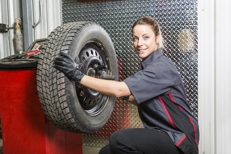 A Mechanic woman working on car in his shopの写真素材