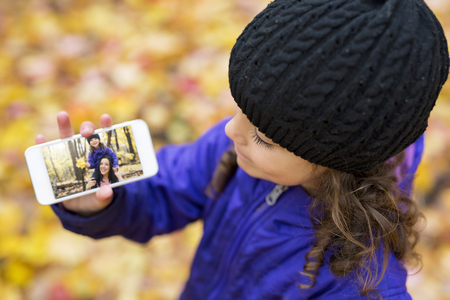 An Adorable little girl in a autumn forestの写真素材