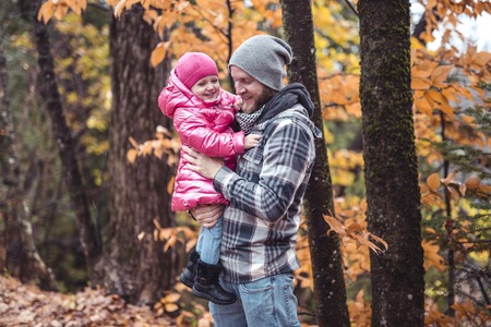 A Daughter with dad walking in the autumn forestの写真素材